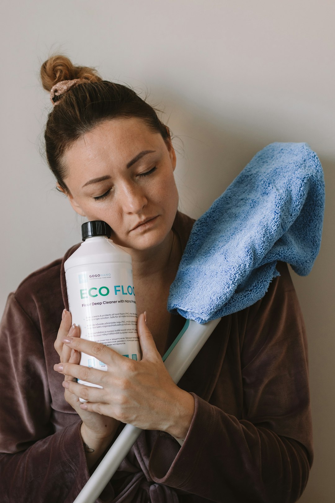 woman-resting-her-head-on-cleaning-supplies-nic4bs62ab4